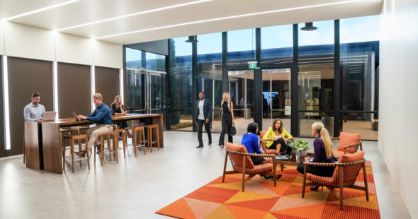 Businesspeople enjoying the workspace and seating areas in the lobby of The Launch office building lobby in Irvine, CA