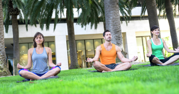 A group of people doing yoga as part of a KINETIC® group fitness class