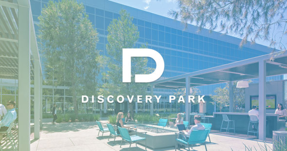 Photography of people enjoying The Commons, an outdoor workplace and gathering area, at The Quad at Discovery Park in Irvine, CA with the Discovery Park logo and filter overlaid