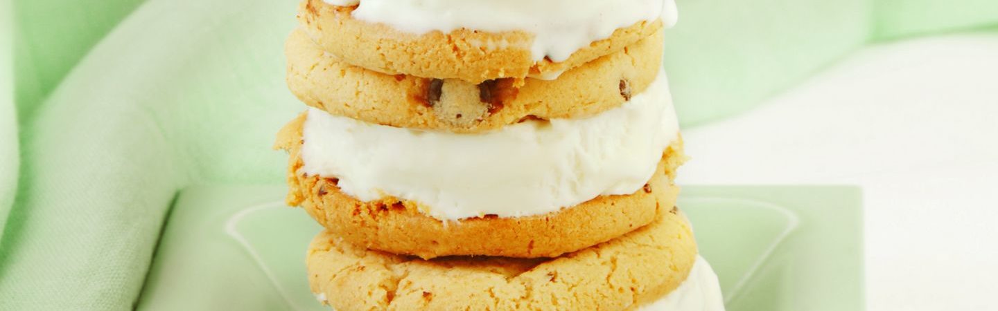 Chocolate chip cookie with vanilla ice cream sandwich on a mint green plate