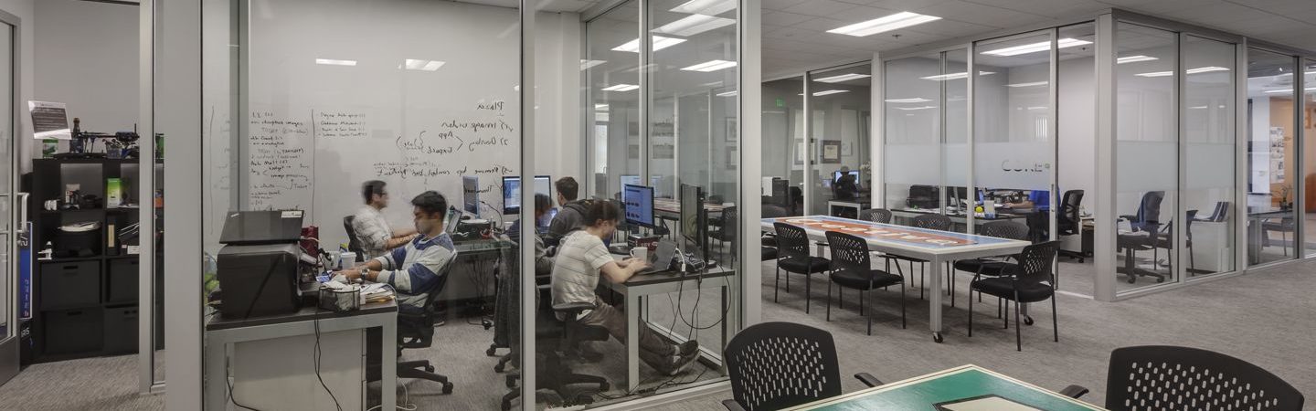 A group of young men sitting in a shared office space and doing work