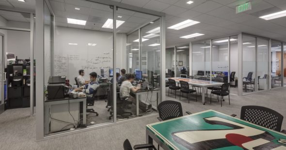 A group of young men sitting in a shared office space and doing work