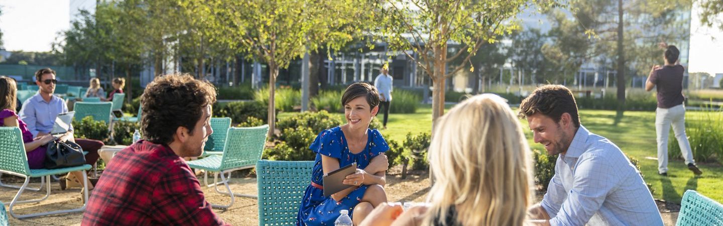 Photography of people enjoying The Commons, an outdoor workplace and gathering area, at The Quad at Discovery Park in Irvine, CA