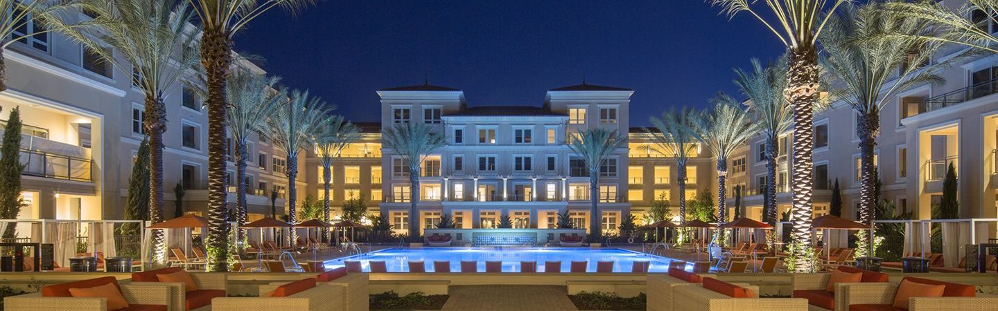 Photography of an Irvine Company Apartment community at night with outdoor seating and lit pool