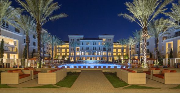 Photography of an Irvine Company Apartment community at night with outdoor seating and lit pool