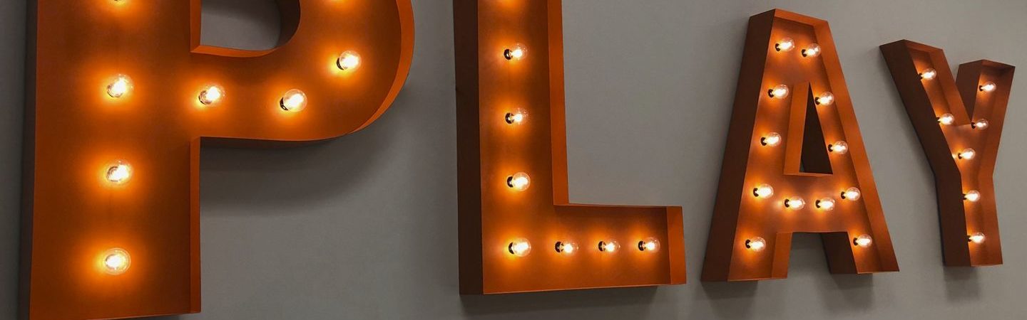 Lit "PLAY" signage on a wall