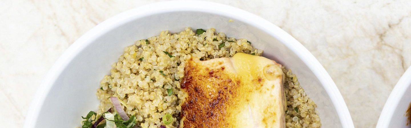 Couscous topped with roasted chicken breast, chopped green onion, and a small side salad
