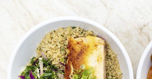 Couscous topped with roasted chicken breast, chopped green onion, and a small side salad