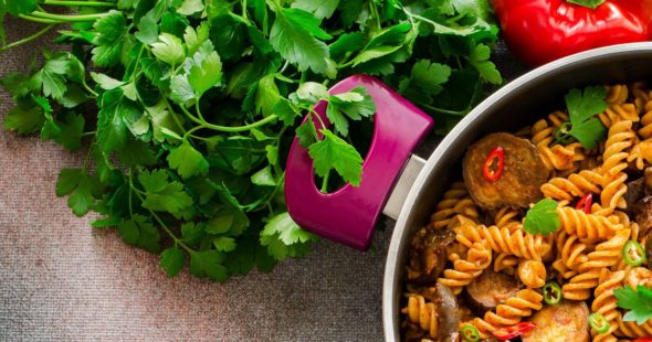Spiced fusilli pasta in a pot with fresh parsley and bell pepper