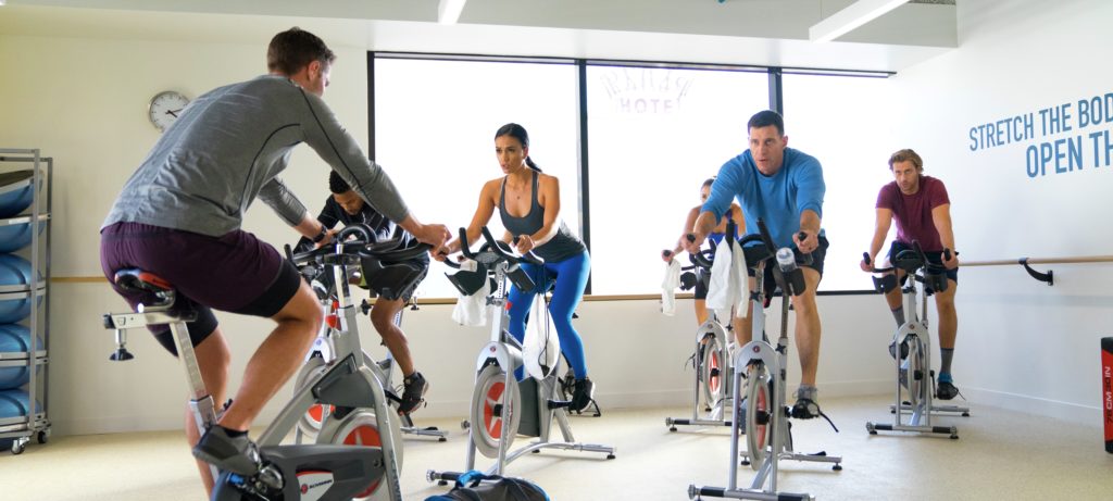 Group fitness class with an instructor on spin bikes at a KINETIC® Fitness Center