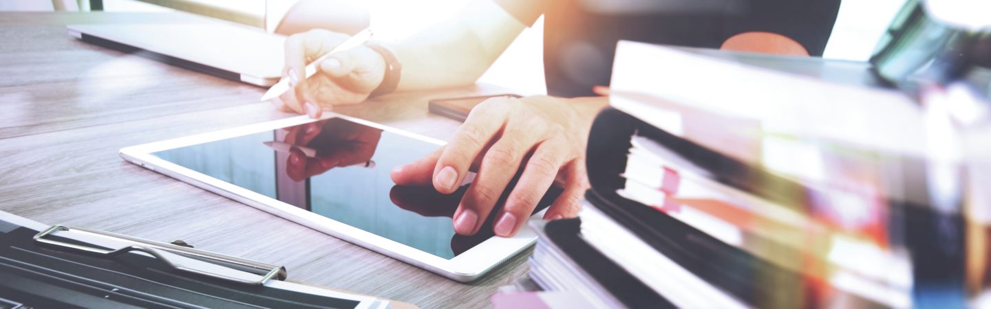 Person holding a stylus and working with a tablet
