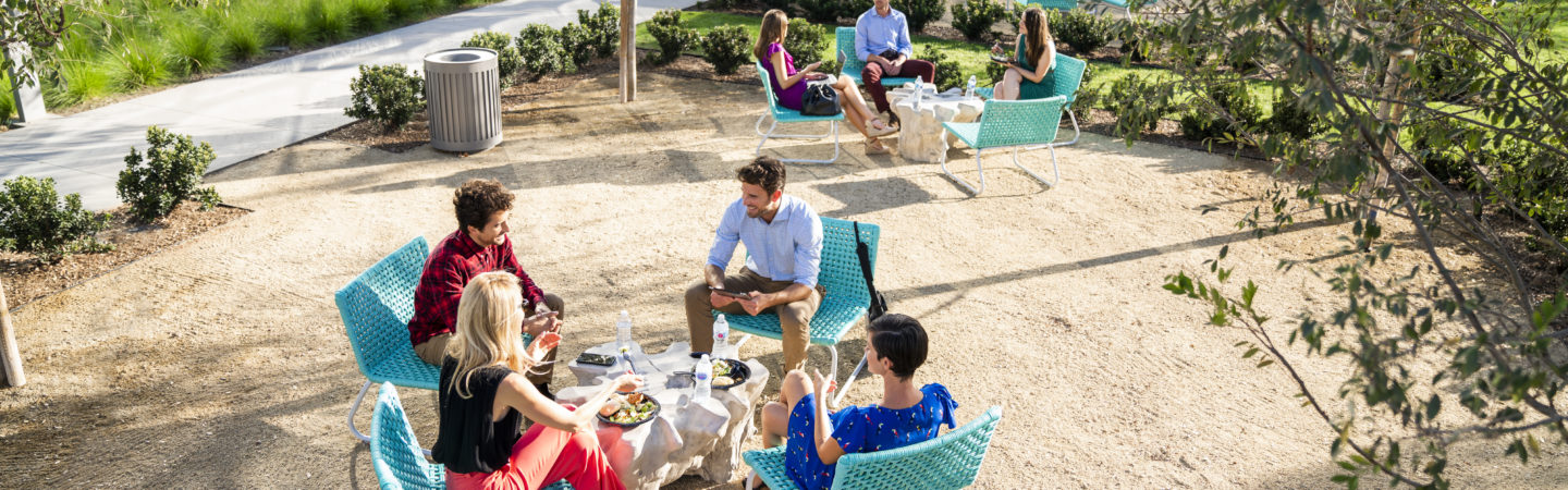 Photography of people enjoying The Commons, an outdoor workplace and gathering area, at The Quad at Discovery Park in Irvine, CA