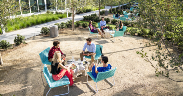 Photography of people enjoying The Commons, an outdoor workplace and gathering area, at The Quad at Discovery Park in Irvine, CA