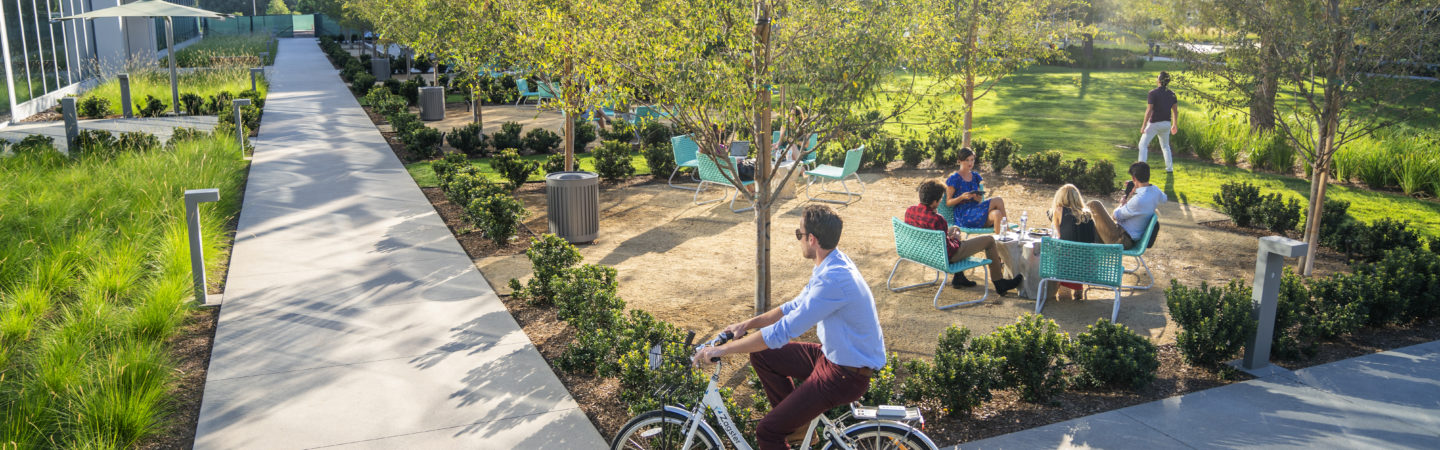 Photography of people enjoying The Commons, an outdoor workplace and gathering area, at The Quad at Discovery Park in Irvine, CA