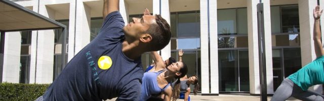 A group of people doing yoga as part of a KINETIC® group fitness class