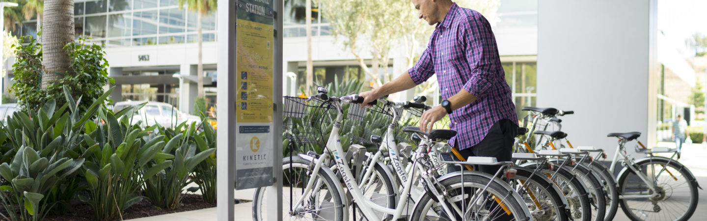 Photography of a man renting a Zagster bike from the bike share program offered by Irvine Company