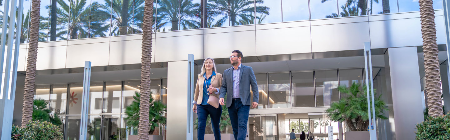Photography of two businesspeople walking out of the 400 Spectrum Center lobby in Irvine, CA