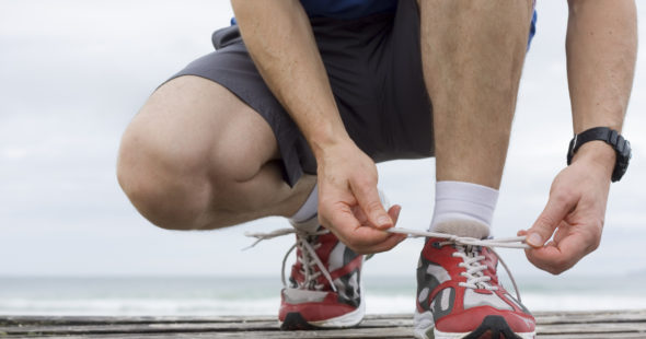 Athlete tying his red running shoes