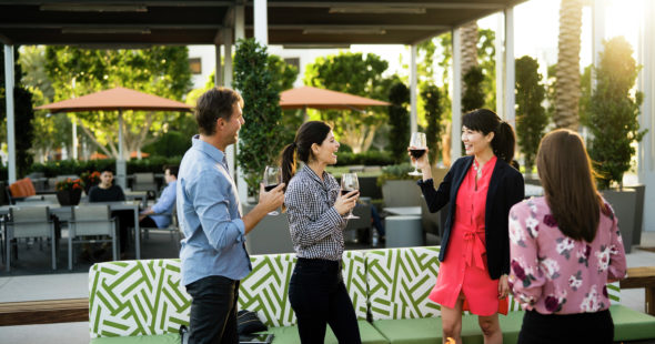 Photography of people enjoying The Commons, an outdoor workplace and gathering area, at 400 Spectrum Center in Irvine, CA