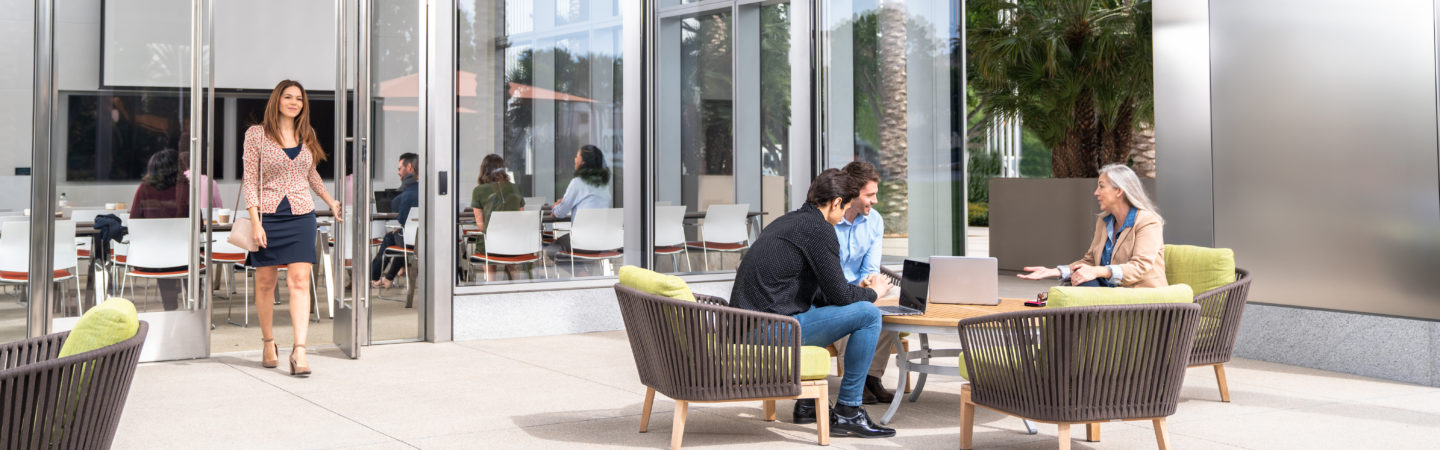 Photography of people using the outdoor seating areas and nearby conference room at 400 Spectrum Center Drive in Irvine, CA