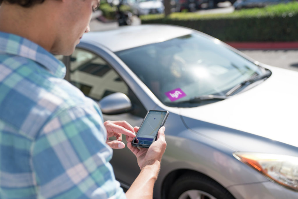 Photography of a young man setting up a ride with Lyft